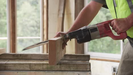 tabla de corte de trabajador de la construcción con sierra