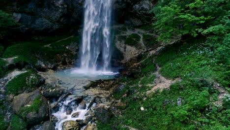 man with beard is doing waterfall-meditation under big waterfall