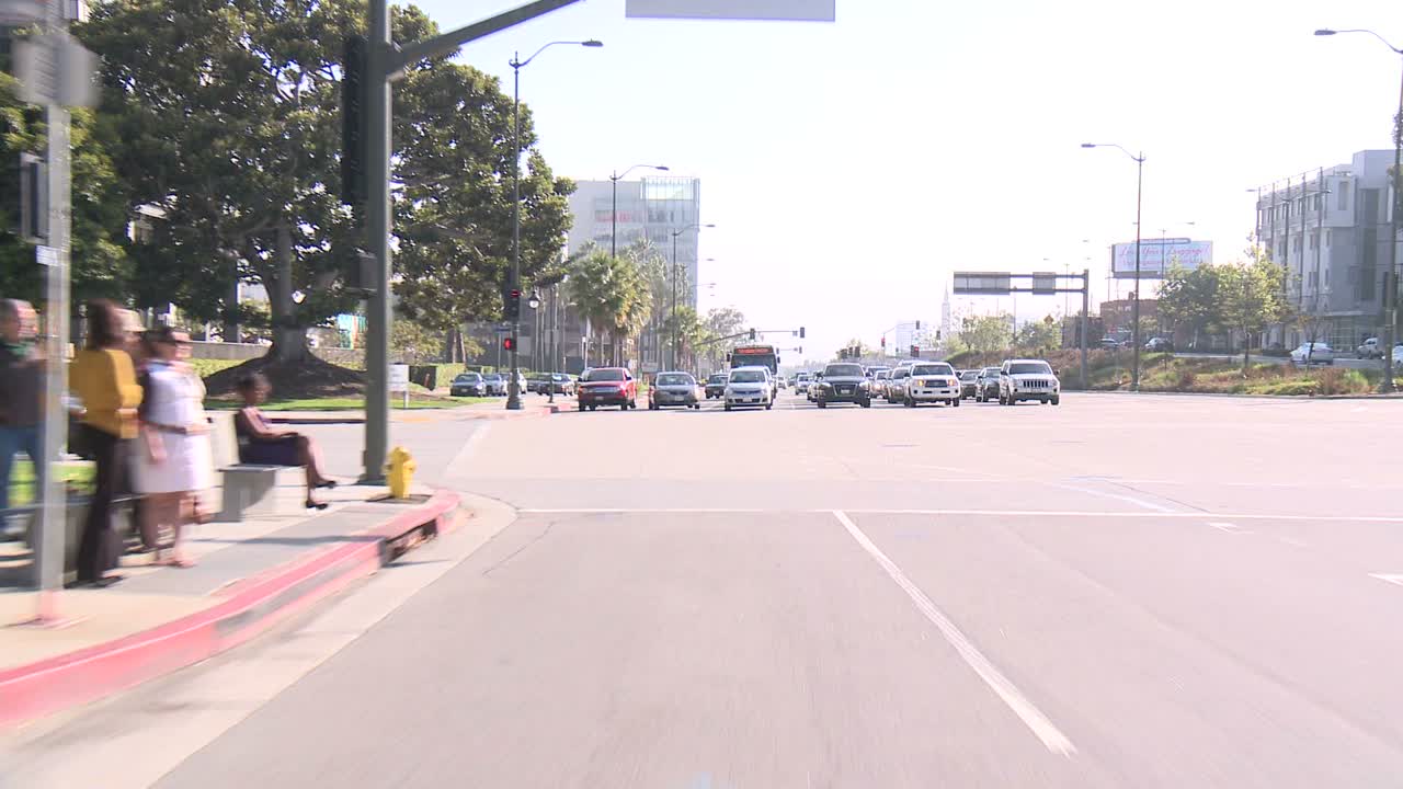 un automóvil viaja a lo largo de una calle en la ciudad del siglo de los ángeles como se ve a través de la ventana trasera 3