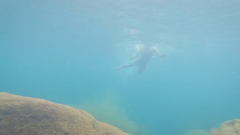 Junger-Mann-Schwimmt-Tagsüber-Im-Klaren-Blauen-Wasser-Aus-Niedrigem-Winkel