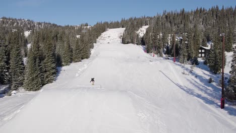 4k aerial of snowboarder in the fun park piste making a jump on a sunny winter day in norway