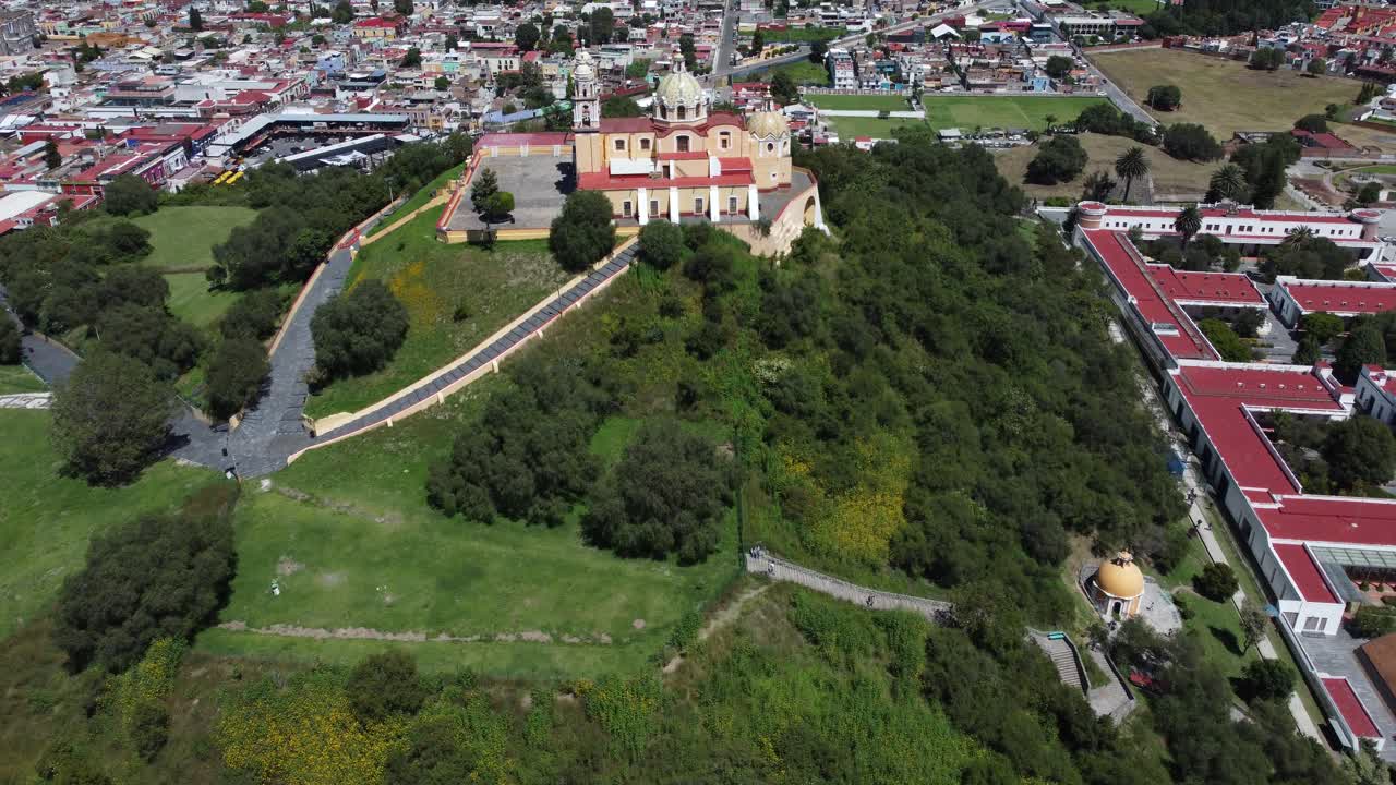 una amplia filmación de la catedral de cholula en méxico, con la ciudad detrás como fondo