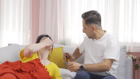 el hombre dando medicina a su esposa enferma.
