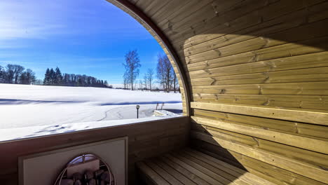 Inside-thermowood-barrel-sauna-looking-outside-through-glass-window,-sunny-weather