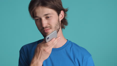 caucasian man in front of camera on blue background.