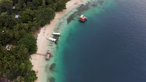 boats at the white sand beach of san pablo island philippines