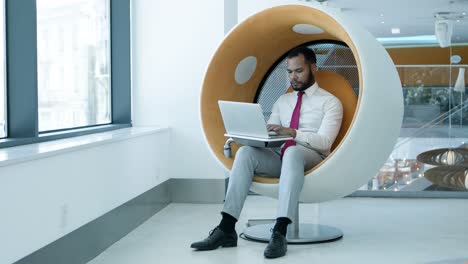 hombre de negocios serio usando una computadora portátil