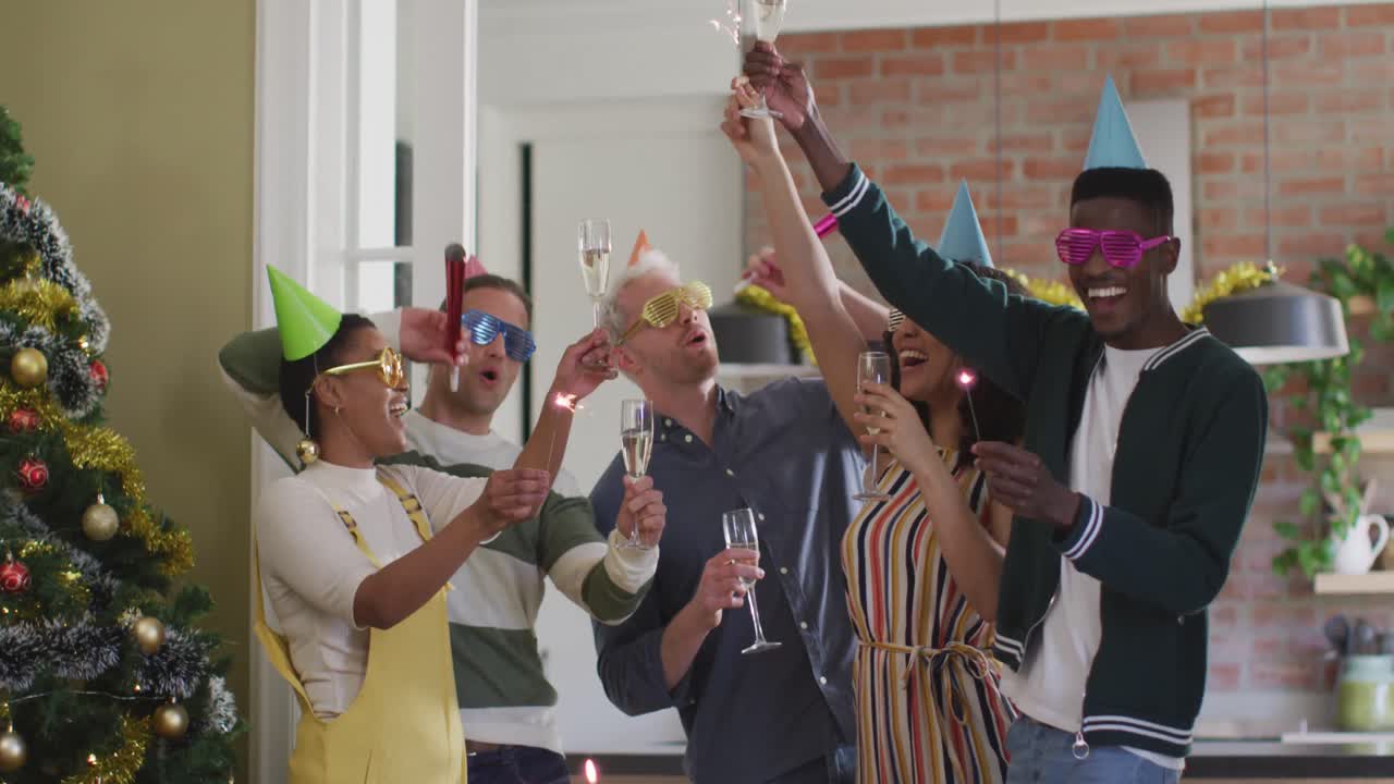 Happy group of diverse friends in party hats celebrating together, toasting with vine