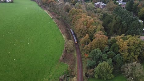 tilt-up reveal of train crossing countryside and scottish urban residential area