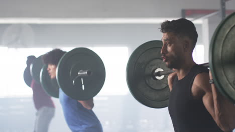 lifting barbells, men exercising in gym, focusing on strength training