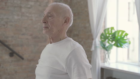 old man stretching and exercising at home 1