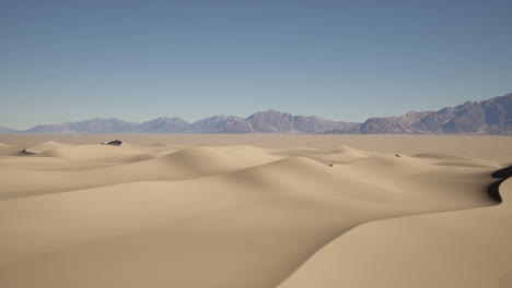 vasto paisaje desértico con dunas de arena y montañas en la distancia