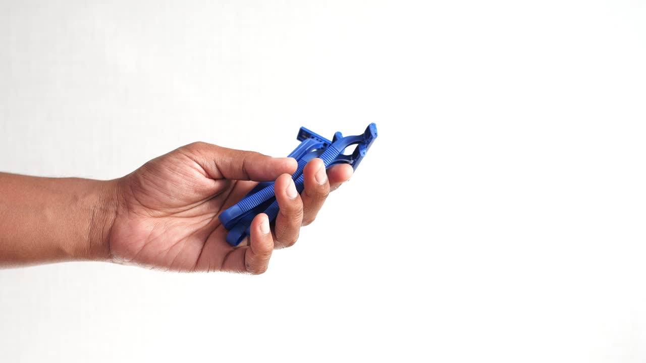 la mano de un hombre con tres afeitadoras azules