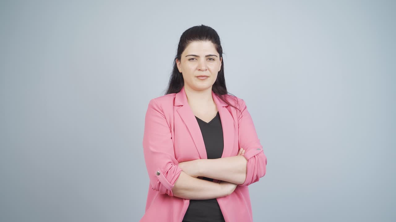 Business woman with arms folded and laughing at camera.