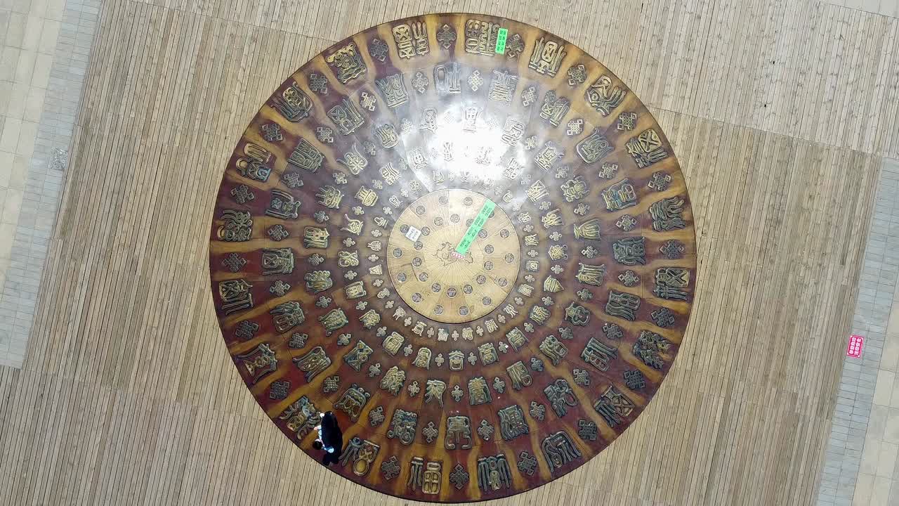 People walk past admiring mini dome with ancient inscriptions in Weihai, China, bird's eye view