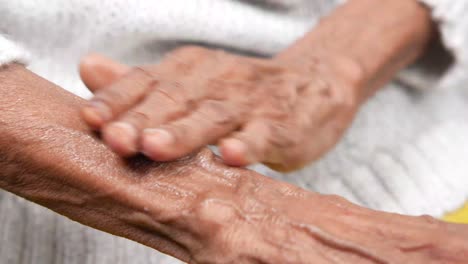 elderly person applying lotion to their arms