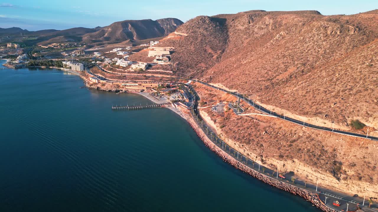 Scenic coastal highway, desert cliffs and La Paz Malecón at golden hour