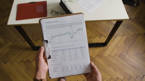 hands holding a business growth report with charts and data