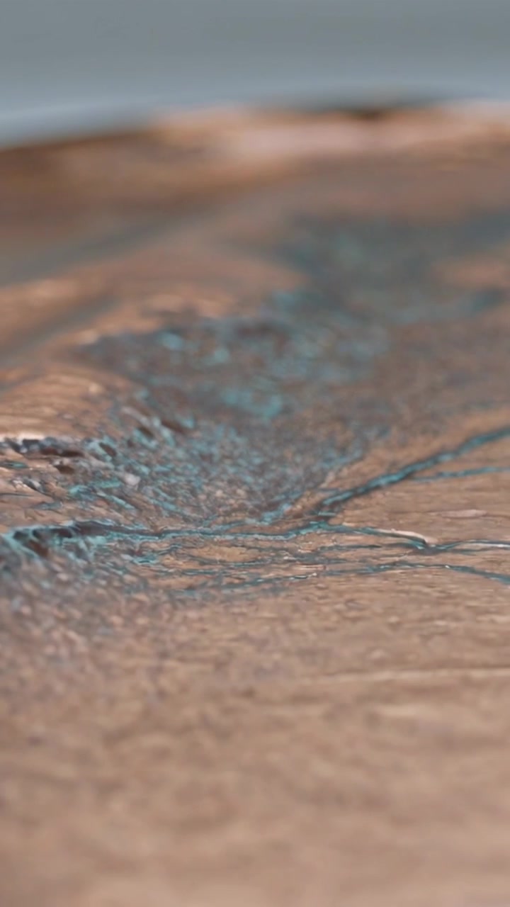 Video verticale: Telecamera in movimento che mette a fuoco scanalature di bronzo in studio, mostrando verderame