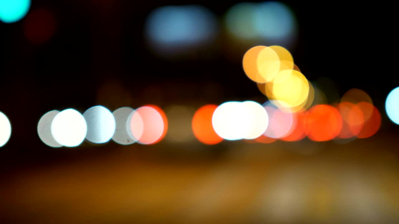 conducir un coche a través de la carretera de la noche, la autopista. luces desenfocadas calle de los ángeles resumen. ciudad fondo borroso. movimientos círculos bokeh de tráfico nocturno.