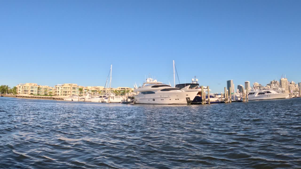 Yacht ormeggiato al porto turistico con lo skyline della città.