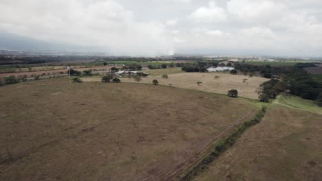 Vista-Aérea-De-Extensos-Campos-Bajo-Un-Cielo-Nublado