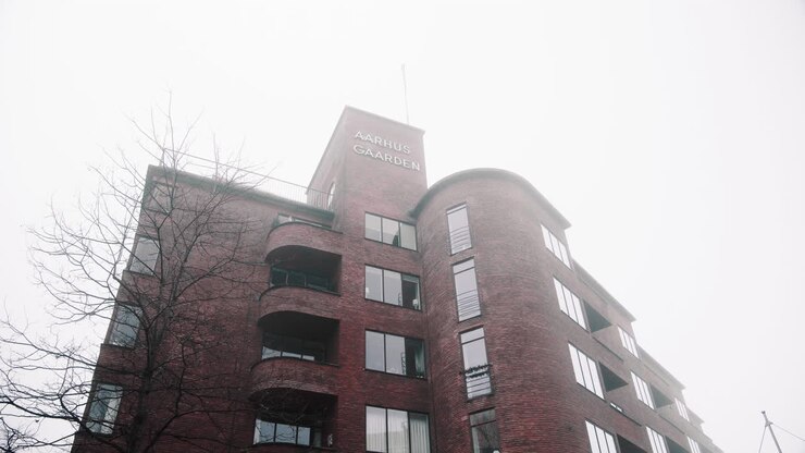 Aarhus Gaarden, vecchio edificio in mattoni nel centro città, inverno nebbioso e nuvoloso
