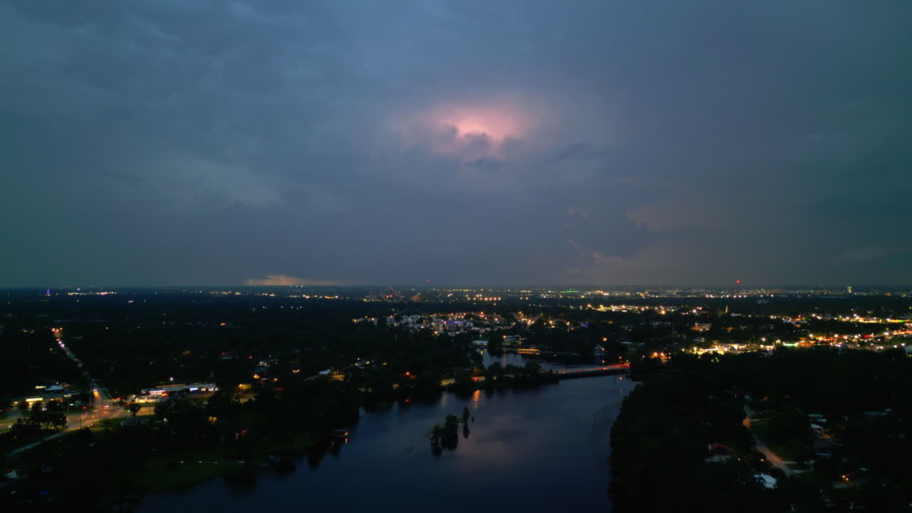 Glowing lightning storm over Tampa with flashing clouds and distant city lights