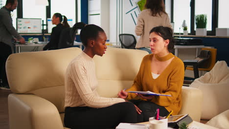 Joven-Mujer-Diversa-Sosteniendo-Un-Documento-En-Papel-Discutiendo-Sobre-El-Contrato