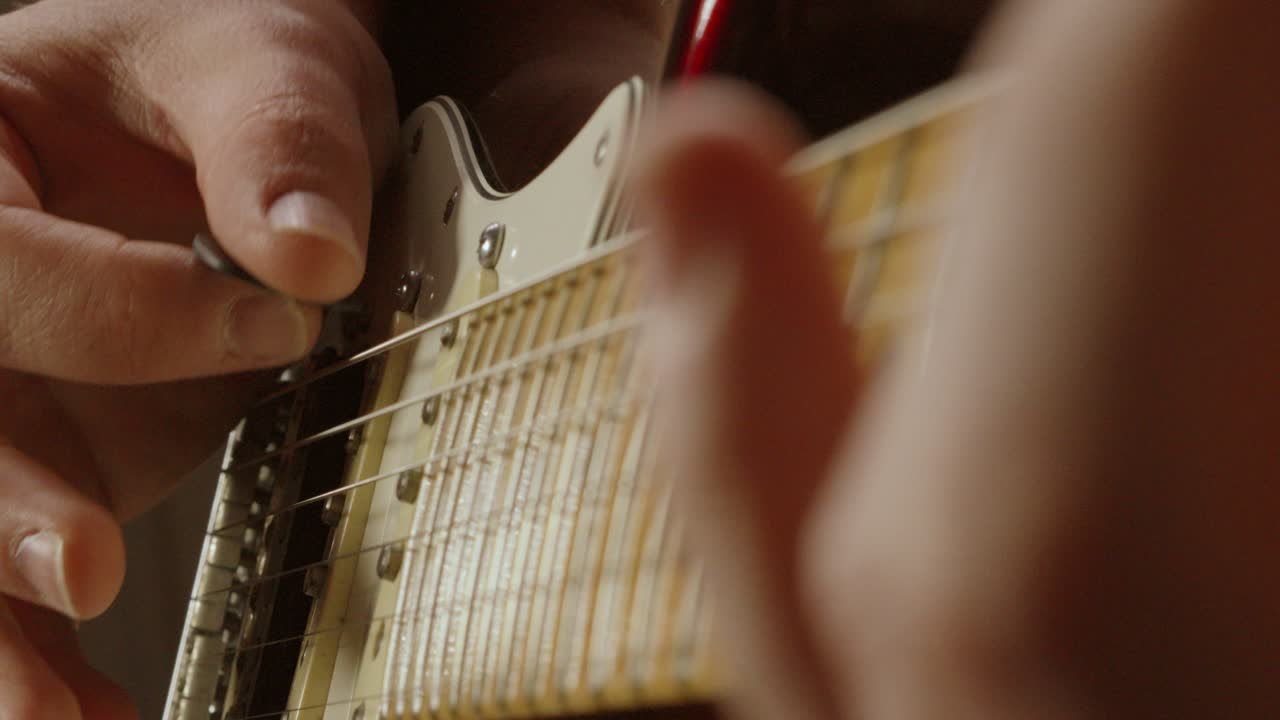 Guitarist Hand Close Up Plucking Strings and Moving Other Hand on Fretboard Jamming Playing Musical Notes During Band Practice to Improve 4K
