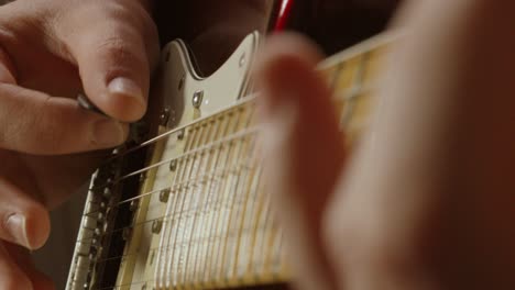guitarist hand close up plucking strings and moving other hand on fretboard jamming playing musical notes during band practice to improve 4k