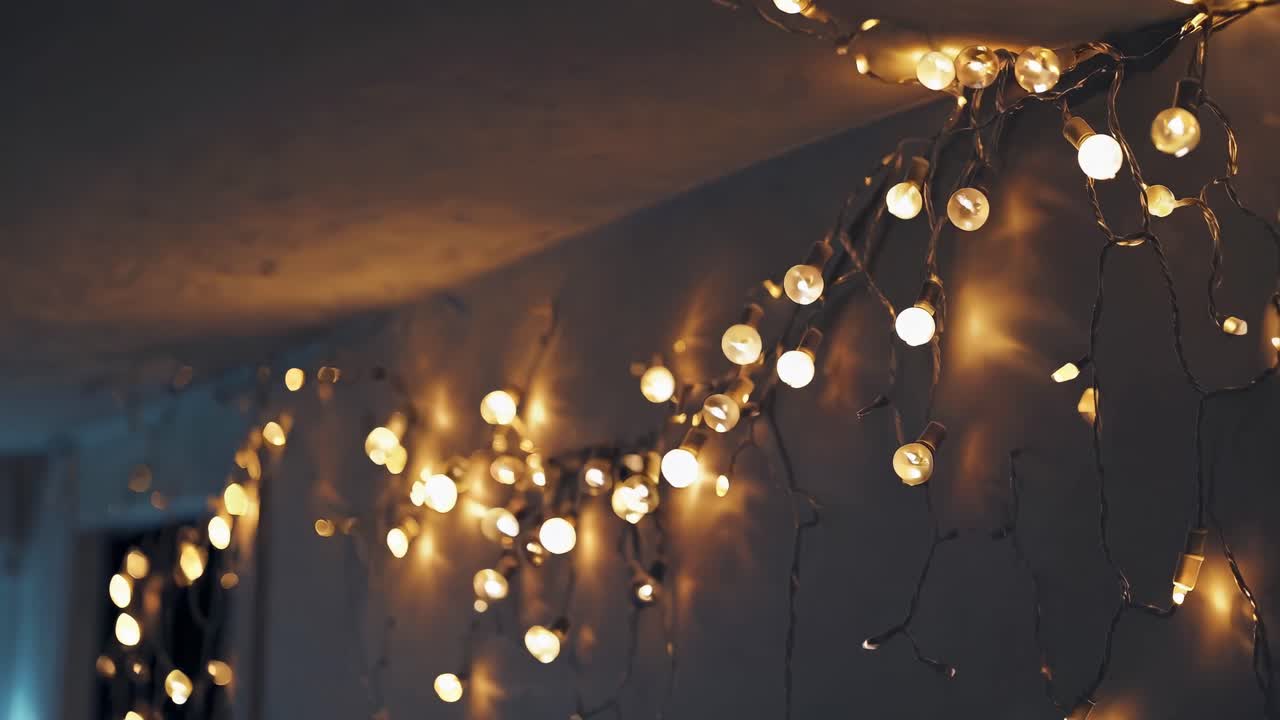 Warm, ambient string lights hang on a wall, captured from a low angle
