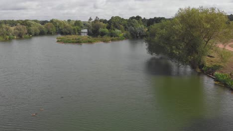 Forward-moving-aerial-drone-shot-over-a-pond-in-the-Ely-great-ouse-river-in-England