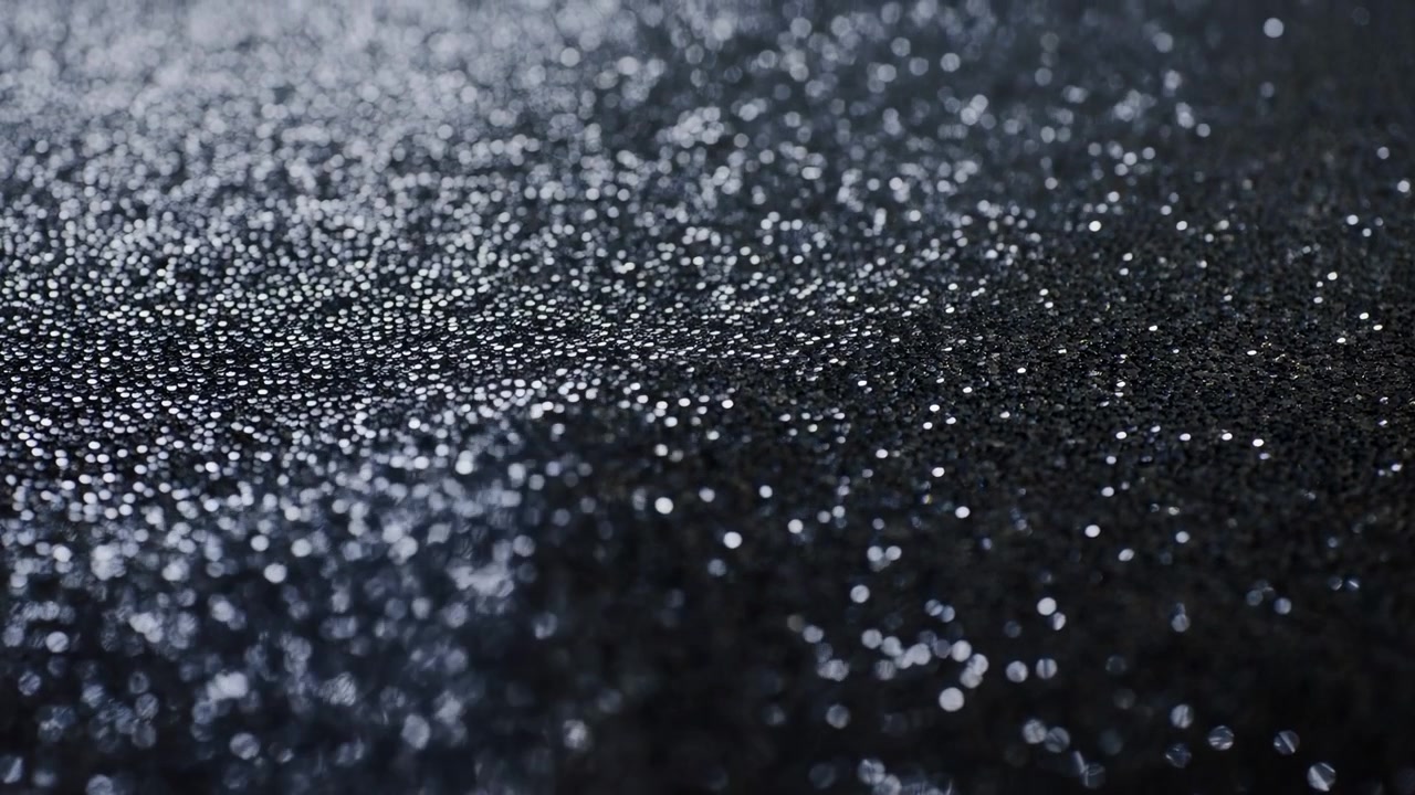 黑色閃光紋理與閃爍散景，濕潤金屬粒子和微小水滴的特寫微距