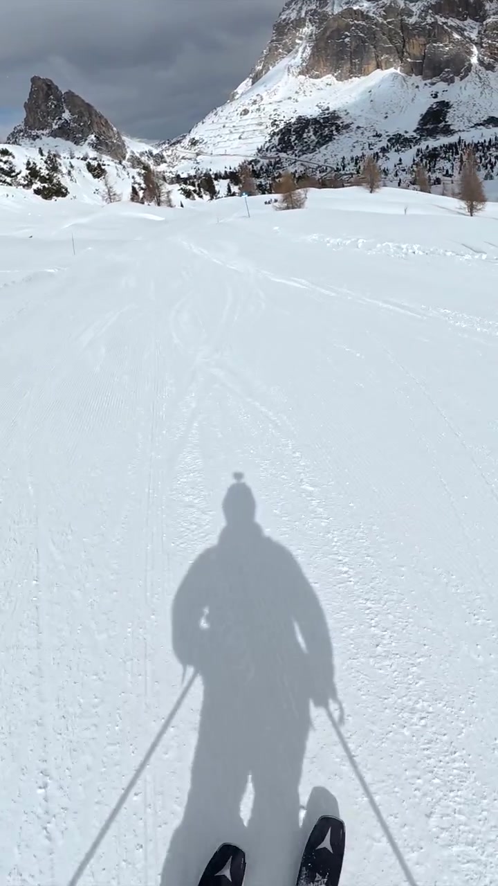 Vista in prima persona di uno sciatore che scende un pendio montano innevato