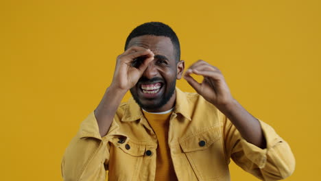 happy man looking through hands