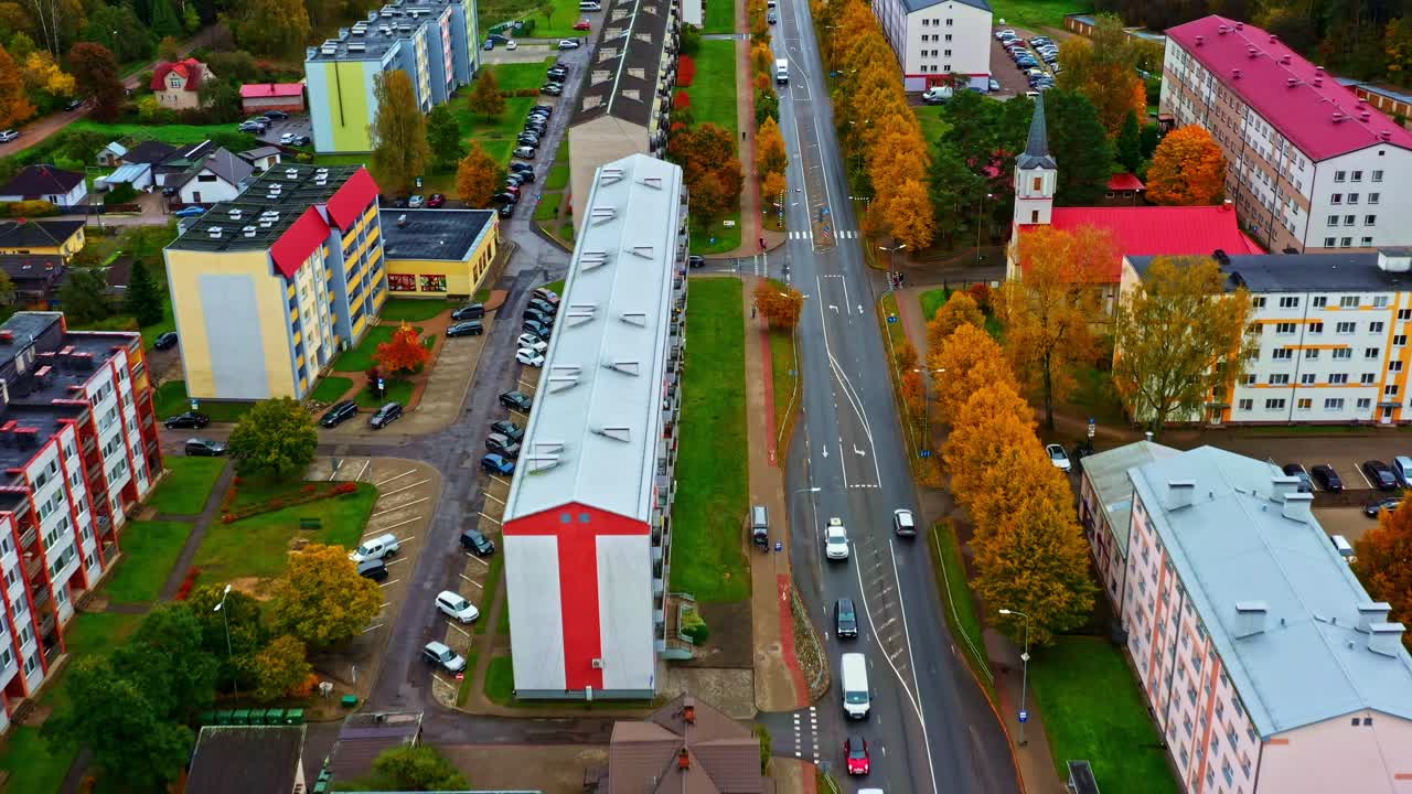Luftfoto av Valmiera by som fanger boligblokker, en travel vei og fargerikt høstløv