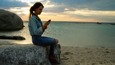 mujer usando teléfono móvil en la playa 4k