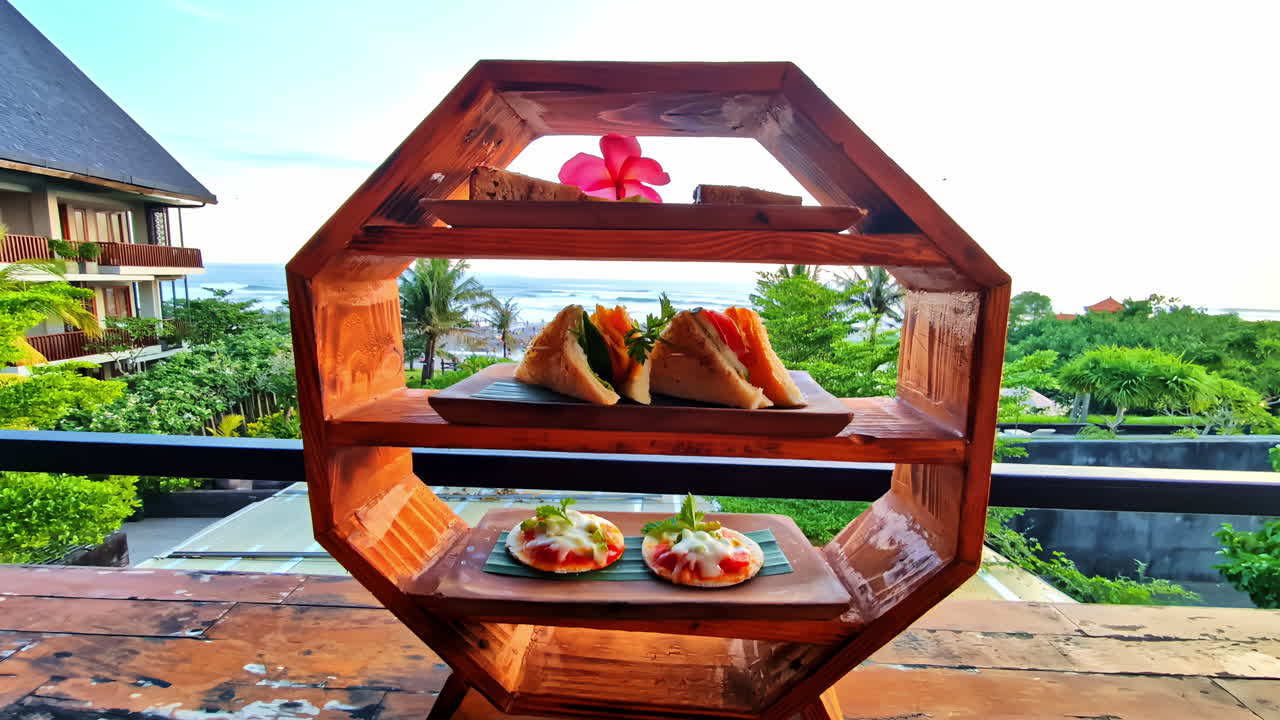 Tropical hotel breakfast with a view of Pantai Berawa, featuring food display