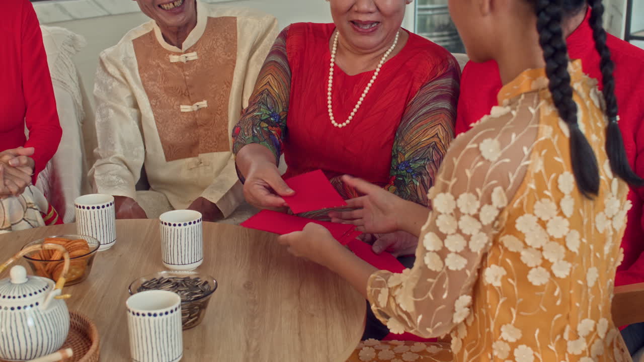Girl Taking Red Envelopes as Gifts for Tet from Her Family Members