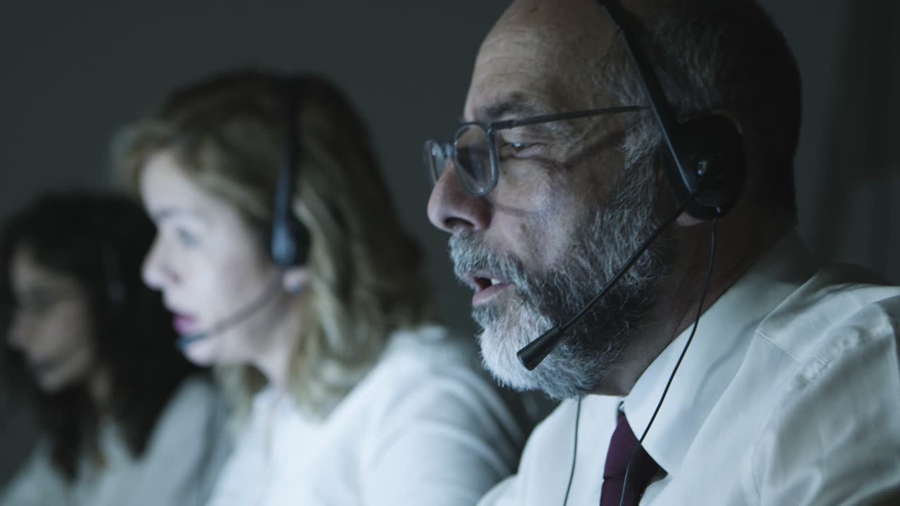 Mature businessman in headset working in office