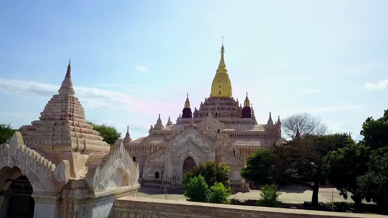A dramatic low-angle establishing shot of the White Temple at Ananda Temple, Bagan, Myanmar, beautifully showcasing the golden Sertok against the backdrop of this iconic spiritual landmark.