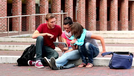 happy students using tablet pc outside on steps