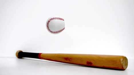 baseball bouncing near a baseball bat