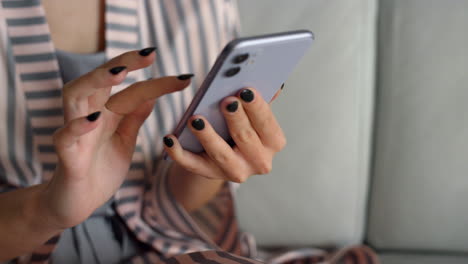 Chica-Sosteniendo-Compras-En-Línea-Con-Teléfonos-Inteligentes.-Manos-Tocando-El-Gadget-En-El-Primer-Plano-De-Casa.