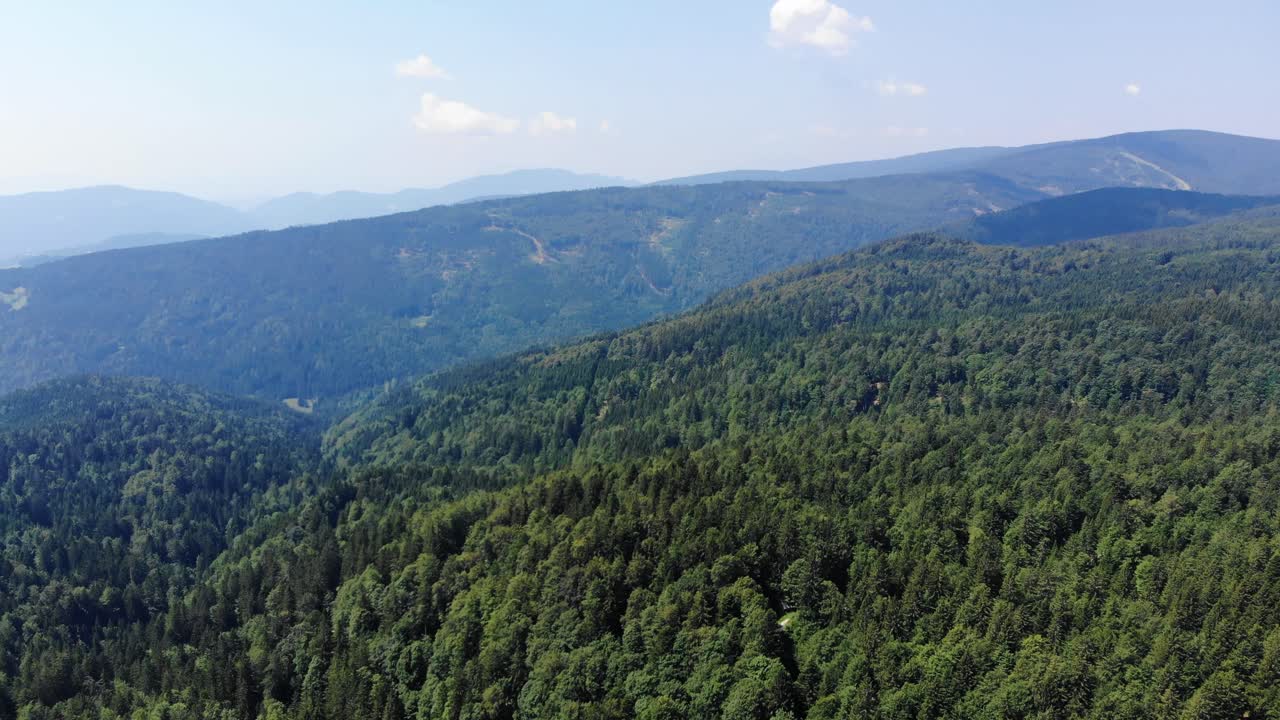 Aerial panning shot of a scenic mountain and forest landscape in eastern Slovenia