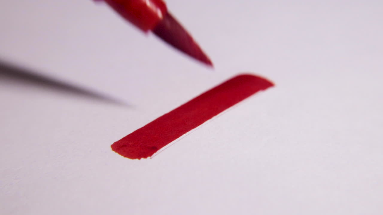 Extreme close up of a red X being drawn on a white blank piece of paper