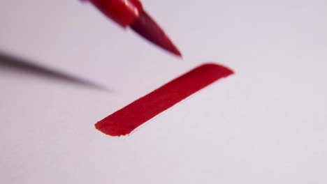 un primerísimo plano de una x roja dibujada en una hoja blanca de papel