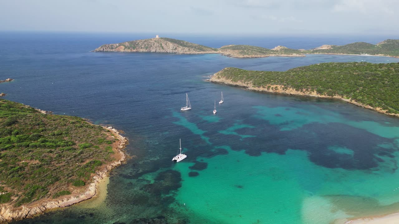 Baía azul turquesa com barcos, ilhas e a praia de Tuerredda em Teulada, Sardenha, Itália - Aéreo 4K
