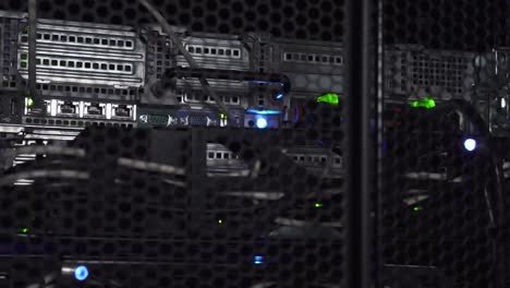la tenue linterna de un pirata informático que pasa sobre un estante de enrutadores y cables de datos